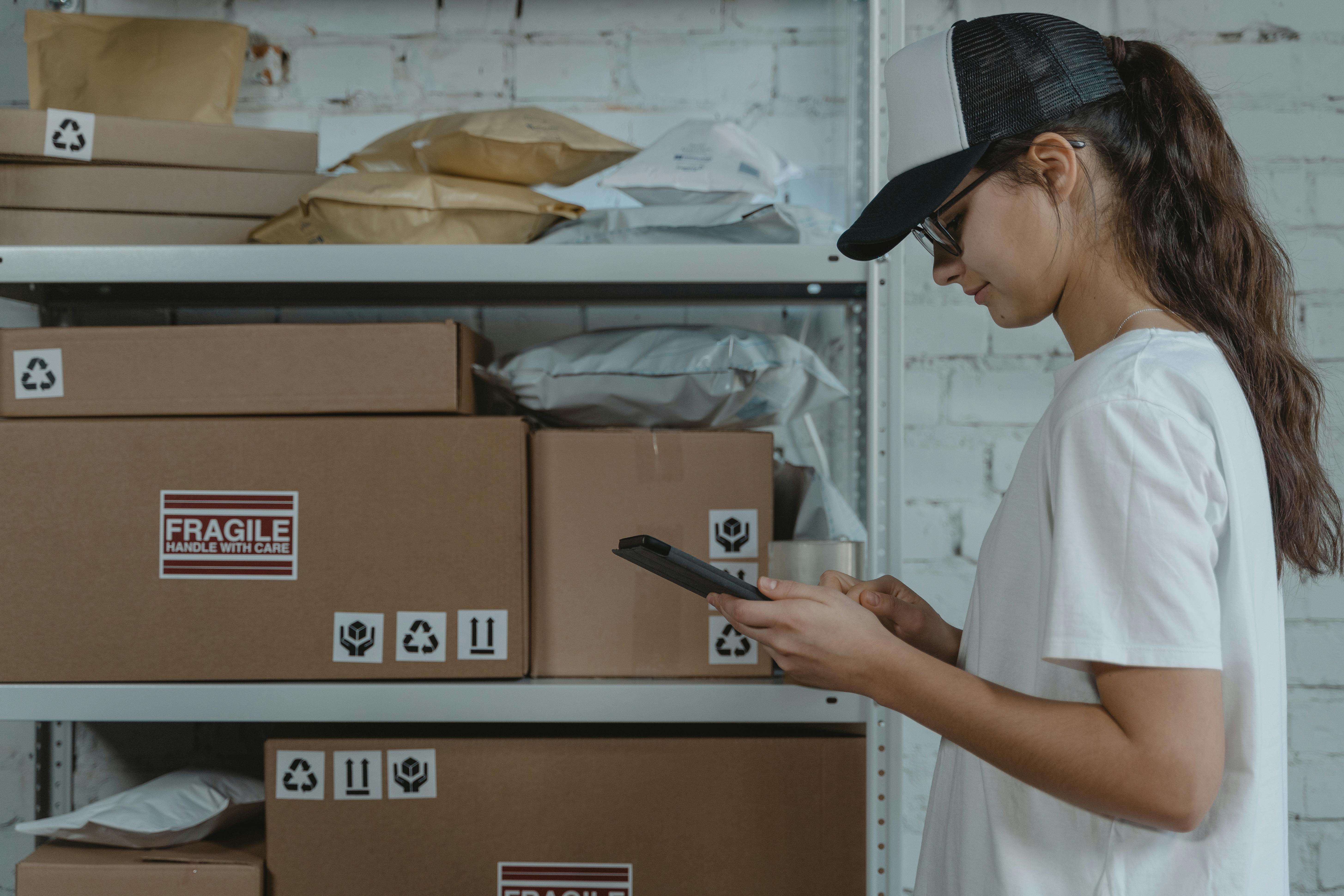 Woman in White Shirt Holding Black Smartphone