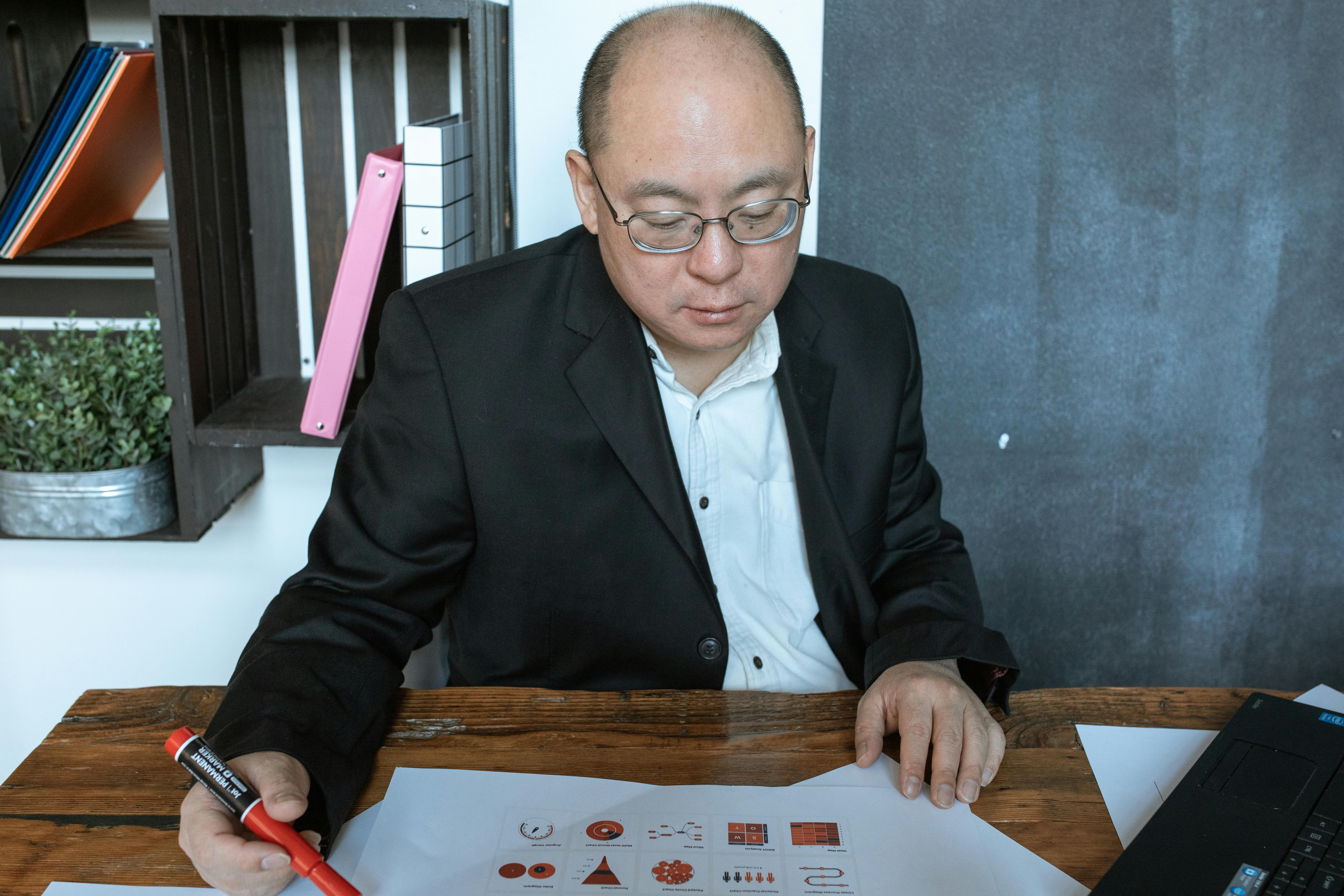 Man in Black Suit Jacket Sitting at the Table