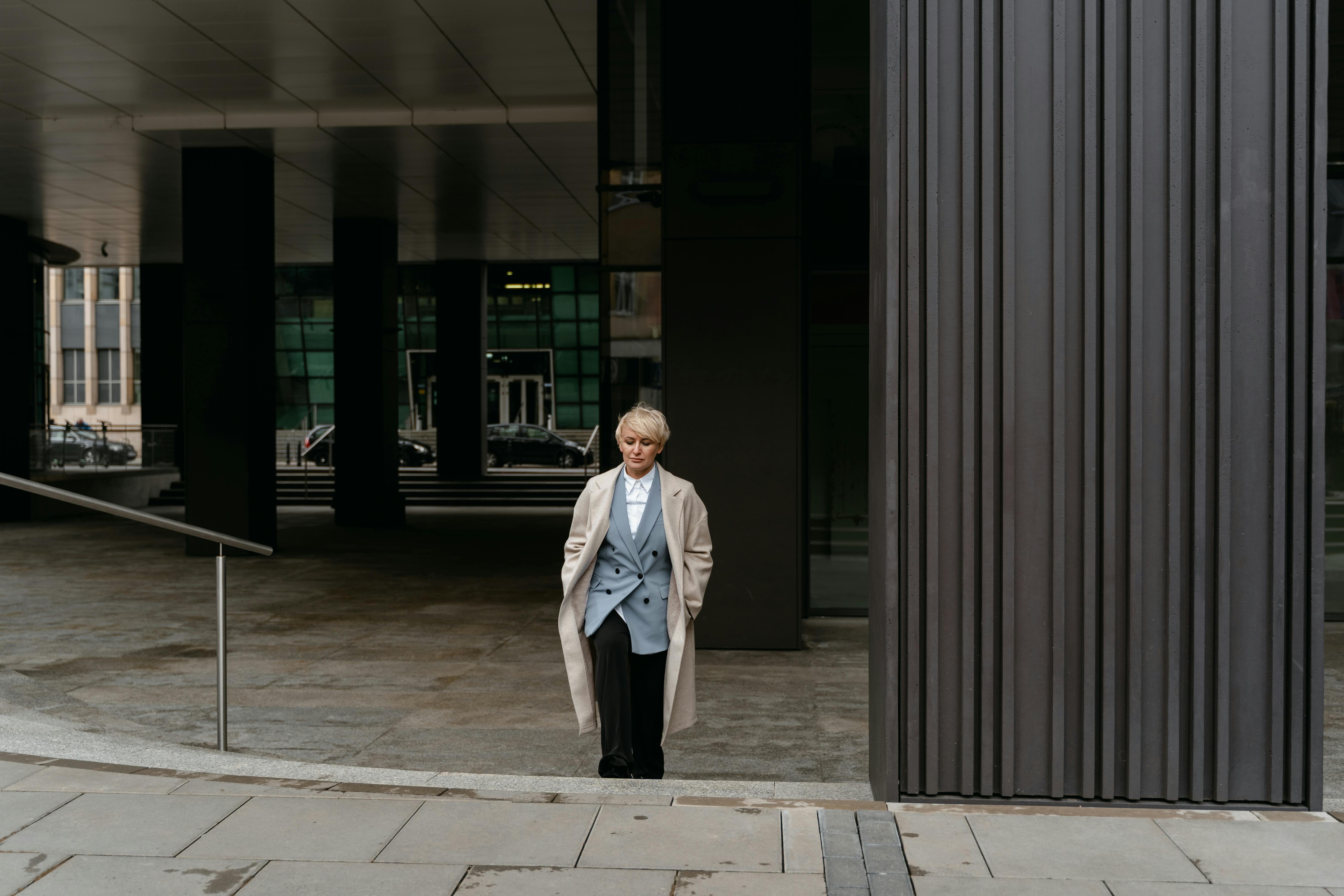 Man in White Coat Standing Near Brown Wall