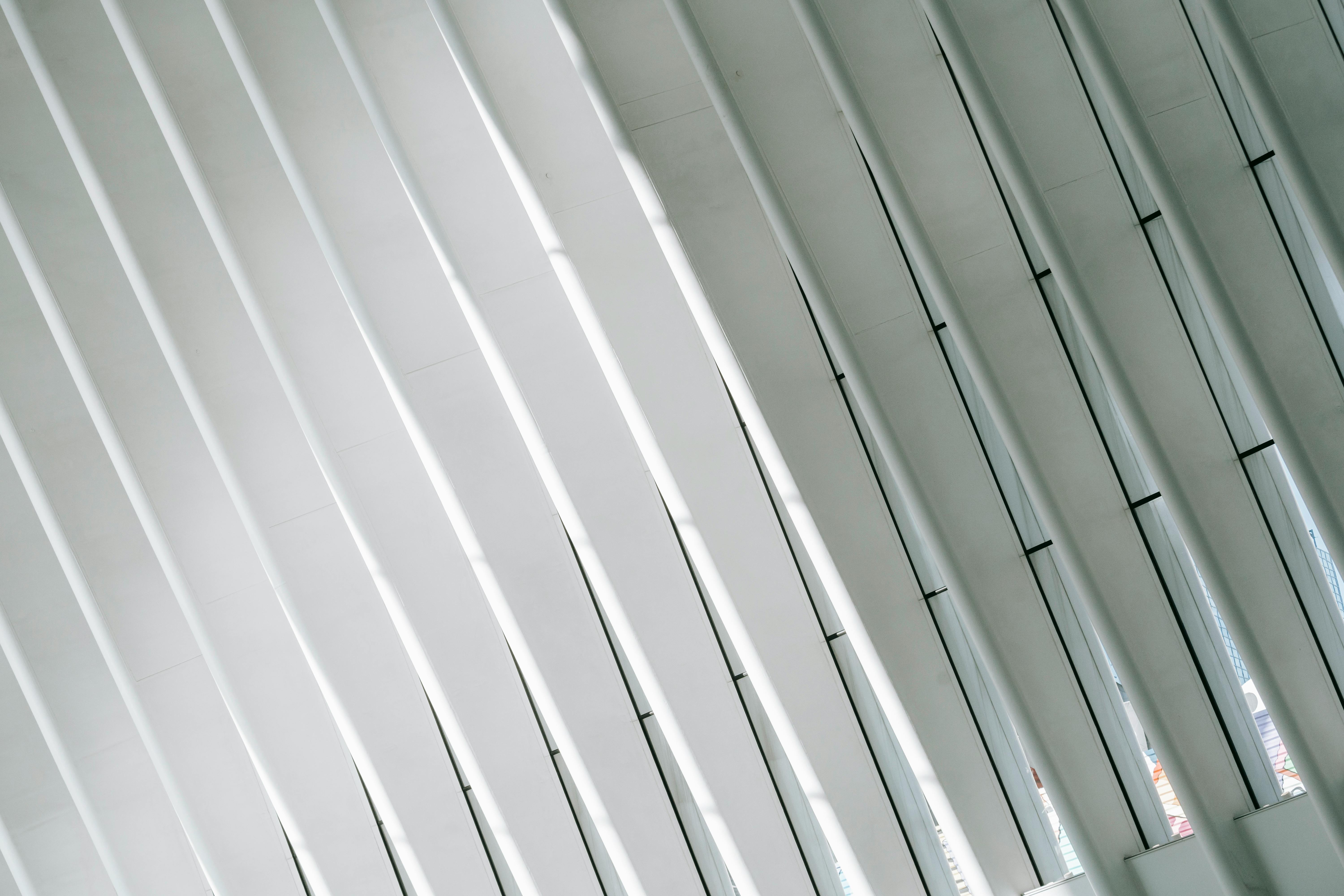 Low angle of geometric white walls with ribs and glass windows in modern minimalist building of terminal in New York